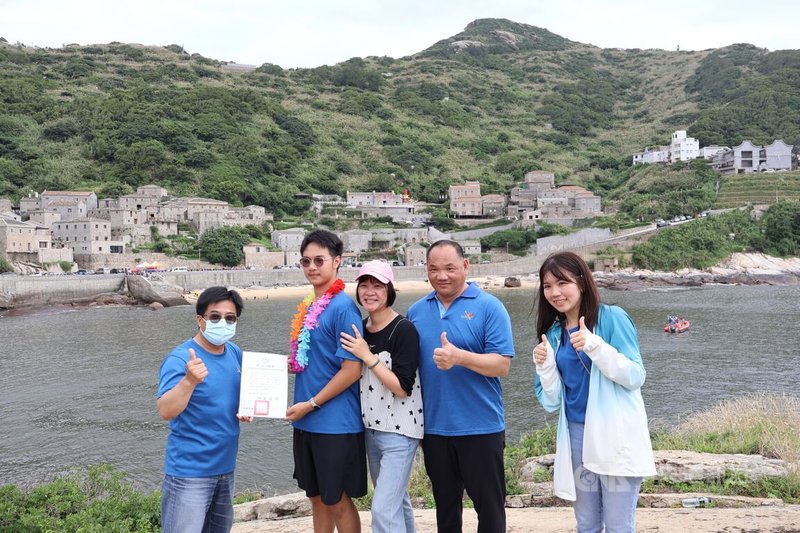 連江縣立中山國中與塘岐國小各11名畢業生11日完成鐵人3項挑戰,划獨木舟到芹壁龜島,中山國中校長蕭建福(左1)在島上頒發象徵取得畢業資格的證書。中央社記者潘欣彤攝 113年6月11日