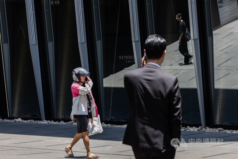 圖為台北市信義區街頭的外送員與上班族。 （中央社檔案照片）