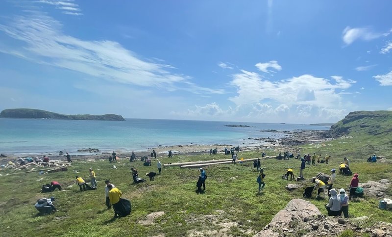 澎湖國家風景區管理處12日在望安散崎港岸際舉辦淨灘活動，近100人響應參與在烈日度高溫下接力搬運所拾海廢垃圾。（澎湖國家風景區管理處提供）中央社  113年6月12日