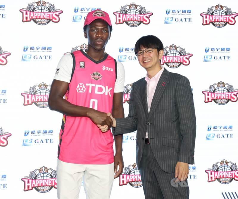 台灣職籃好手阿巴西(左)17日正式加盟日本B1聯盟秋田北部喜悅。圖為阿巴西在記者會中與秋田北部喜悅球團主席水野勇氣(右)握手致意。中央社記者謝佳璋攝 113年6月17日