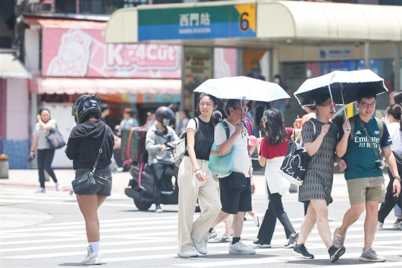 圖為台北西門町太陽熱辣，民眾撐傘遮陽。（中央社檔案照片）