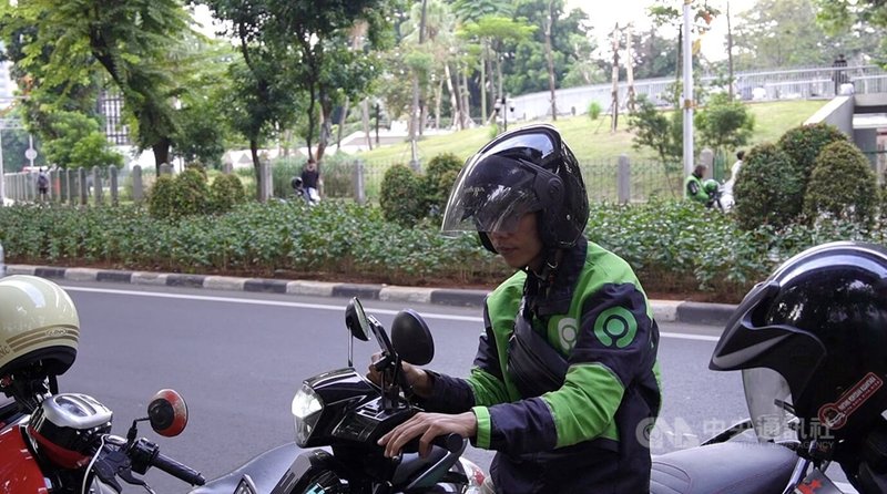 GoTo集团旗下Gojek叫车平台是印尼人常用的手机应用程式，它除了提供汽车和摩托车搭载服务，也能送货及送外卖。图为Gojek司机在路边等待接客。中央社记者李宗宪雅加达摄  113年6月17日