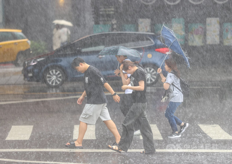 中央氣象署18日下午更新大雷雨即時訊息,擴大警戒區域包含台北市、桃園市、新北市,慎防劇烈降雨。圖為台北市中正區民眾撐傘、以手擋雨,快步過馬路。中央社記者謝佳璋攝 113年6月18日