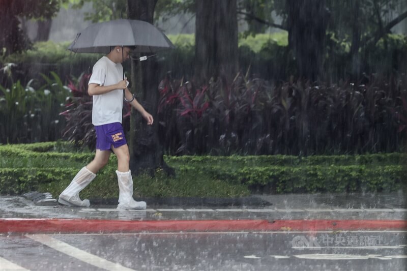 圖為台北市信義區行人穿上鞋套冒雨前行。（中央社檔案照片）