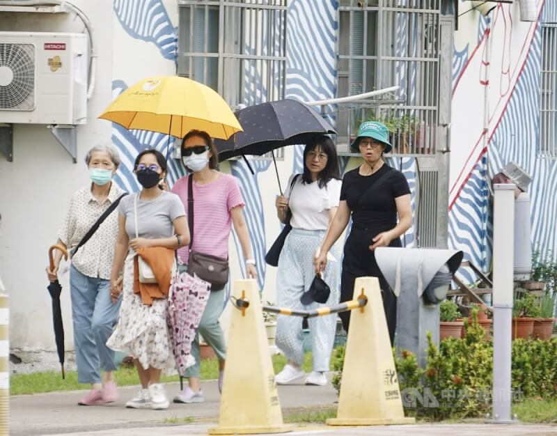 圖為高雄大港橋周邊午後出遊民眾撐傘防曬。中央社記者董俊志攝 113年6月11日