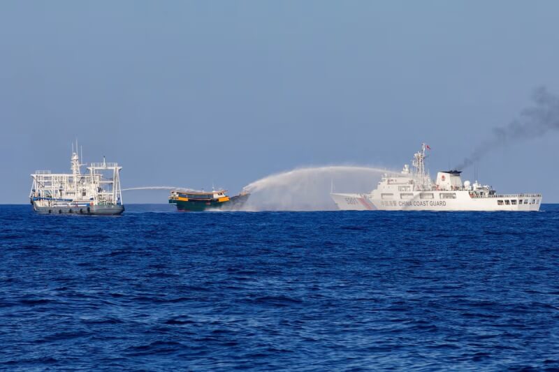 中国海警船只今年5月在菲律宾海军人员进行运补任务时喷水柱进行干扰。（路透社）