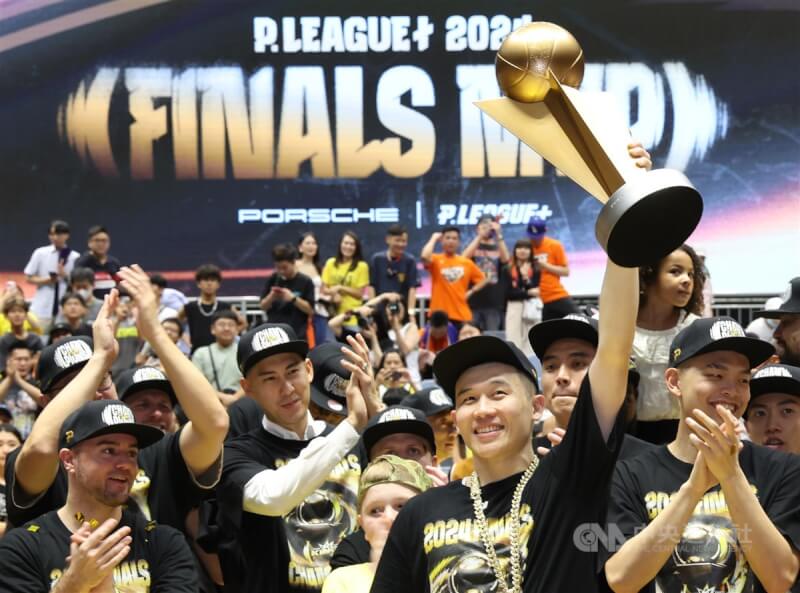 台灣職籃P.LEAGUE+新北國王隊20日在總冠軍系列賽以4比1勝出,拿下隊史首座總冠軍,陣中李愷諺(前右)為球隊奪冠最大功臣,賽後獲選總冠軍賽最有價值球員(FMVP),在隊友掌聲中開心高舉獎座。中央社記者張新偉攝 113年6月20日