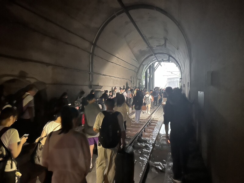 21日下午5時台鐵229班次新自強號疑撞擊落石，民眾下車步行離開隧道。（民眾提供）