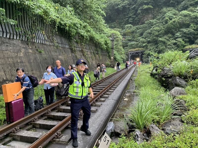 台鐵229班次新自強號21日下午近5時行經和仁段時,疑遭落石砸破駕駛室玻璃,列車緊急停靠清水隧道內,車上乘客陸續撤出,依人員指引沿鐵軌走出隧道、轉搭接駁車。(台鐵提供)中央社記者張祈花蓮傳真 113年6月21日