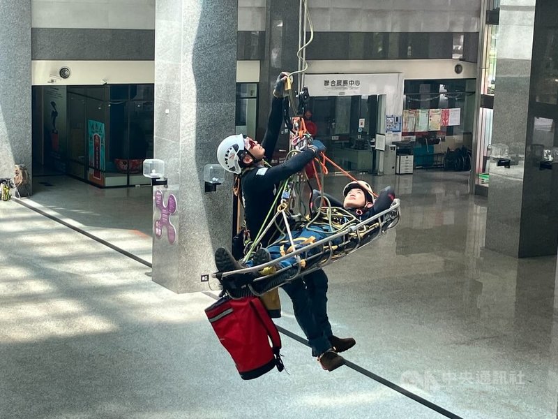 高雄市消防局第四大隊特搜中隊受少年警察隊青春專案7月6日活動邀請演出,人員23日著裝在市府四維行政中心1樓中庭模擬風災時,繩索跨距救援過程,屆時將帶領青少年們學習防災知識。中央社記者張已亷攝 113年6月23日