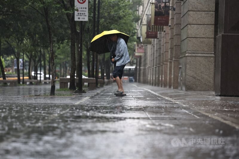 圖為北市信義區23日下午下雨，民眾撐傘遮擋風雨。中央社記者翁睿坤攝 113年6月23日