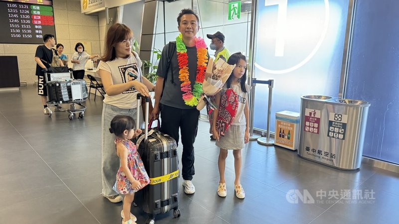 大韓航空KE-189班機22日從韓國仁川起飛往台中時，因飛機失壓返回仁川機場，曾先生（前右2）23日上午順利抵達台中國際機場，妻兒帶著看板、花圈前來接機。中央社記者趙麗妍攝 113年6月23日