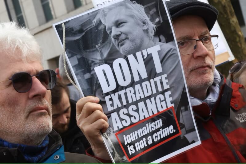 群眾2月20日聚集在比利時布魯塞爾美國大使館外抗議，反對英國將亞桑傑引渡至美國。（路透社）