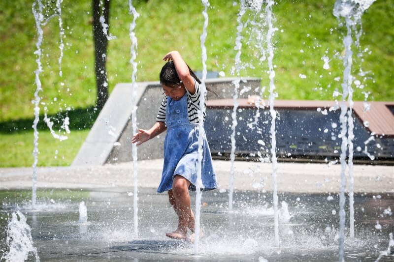 新北市土城區一處公園，孩童穿梭水柱間戲水消暑。（中央社檔案照片）