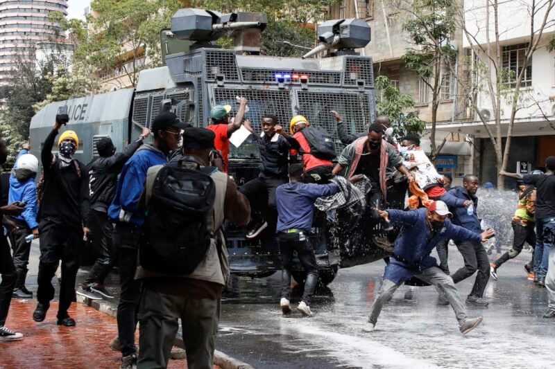 肯亚民众对政府计划加税不满，示威者25日试图阻碍警车，警察使用高压水枪驱离。（路透社）
