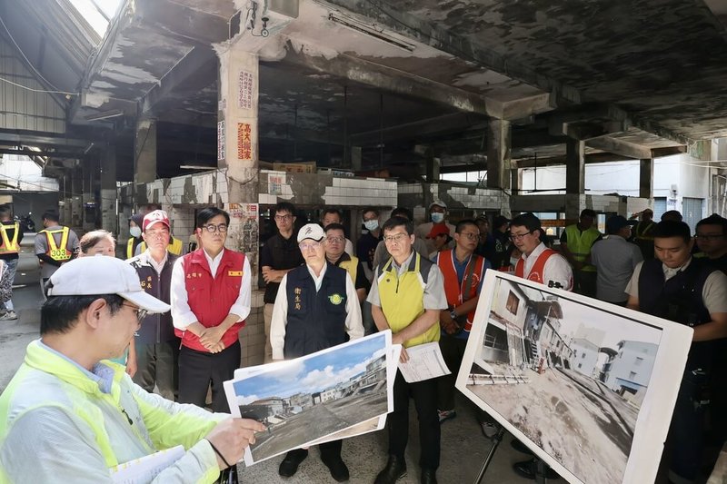 高雄市長陳其邁（後中左紅色背心者）27日率隊至鳳山區北門閒置市場、牛稠埔市場視察登革熱防治工作，專注聽取相關簡報，強調登革熱是環境病，積極環境管理避免產生孳生源非常重要。（高雄市環保局提供）中央社記者林巧璉傳真  113年6月27日