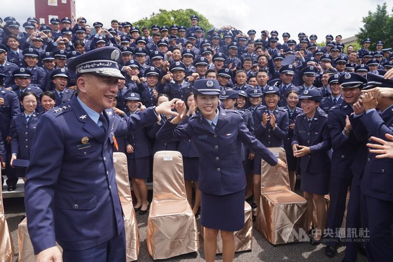 「113年三軍八校院聯合畢業典禮」27日上午在國防大學復興崗校區舉行,畢業生開心與空軍司令劉任遠上將(前左)合比愛心。中央社記者徐肇昌攝 113年6月27日