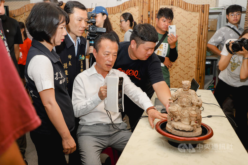 嘉義縣長翁章梁(前中白衣者)29日應邀出席「溪口ㄟ百年香火」新書發表會,會中實際體驗了解如何運用「3D掃描」、「數位建檔」技術完成神像建模。中央社記者蔡智明攝 113年6月29日