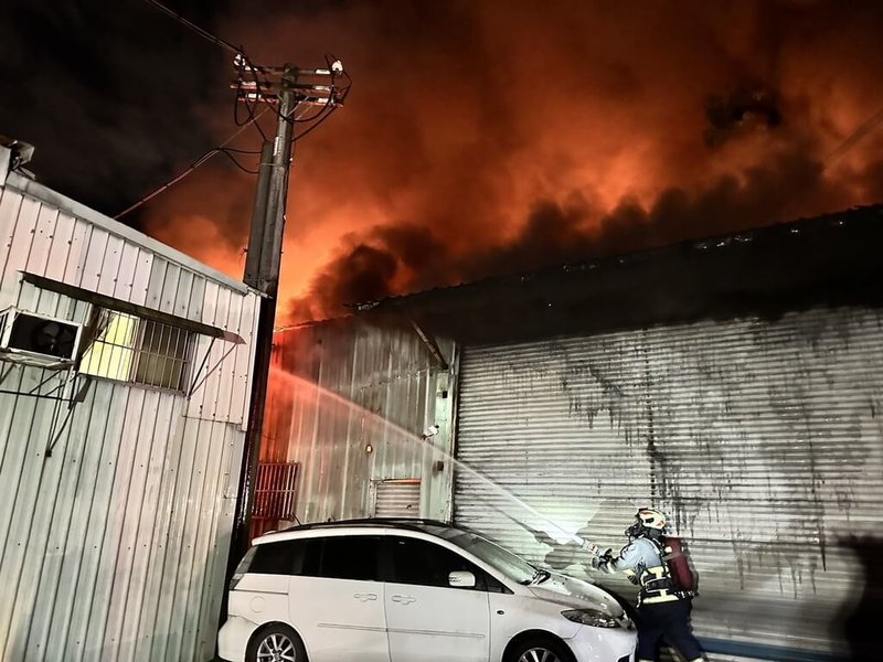 新北市五股區民義路某鐵皮工廠30日晚間冒出火舌濃煙，警消獲報前往馳援，初步了解，火場內部無人受困。（警消提供）中央社記者王鴻國傳真  113年6月30日