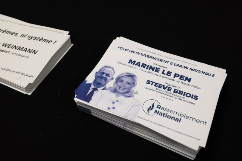 法國國會首輪選舉30日登場。圖為投票站擺放極右翼政黨「國民聯盟」的選票。（路透社）