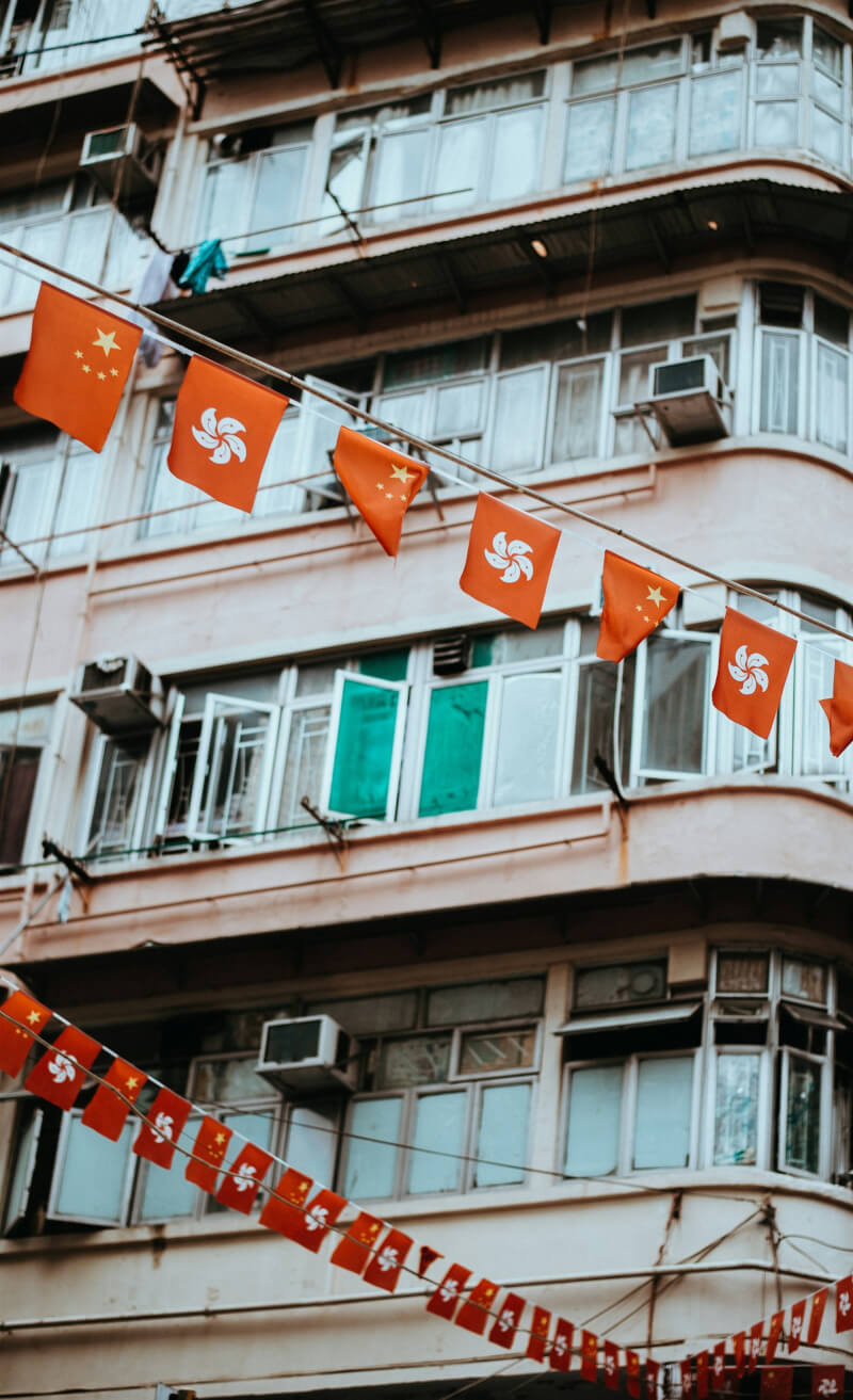 圖為香港街頭掛有香港區旗及中共五星旗。（圖取自Unsplash圖庫）