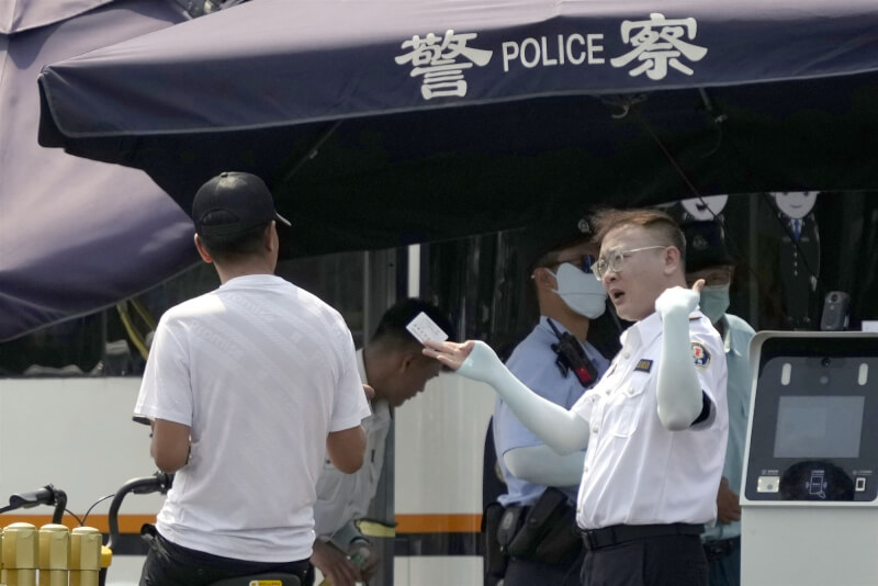圖為6月4日北京一名警察在街頭檢查路人證件。（共同社）