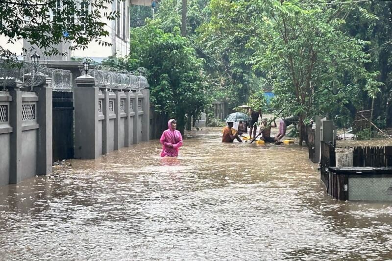 緬甸克欽邦北部密芝那受洪水侵襲，民眾2日在淹水的街道涉水而過。（法新社）