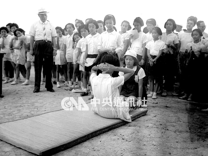 台北市初中聯合招生考試，下午舉行體育考試，圖為考生在做仰臥起坐。中央社記者陳漢中攝 56年7月5日