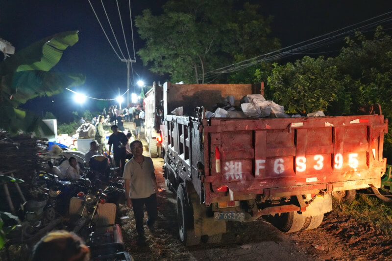 6日凌晨多輛卡車載送砂石赴決堤處進行填補作業。（中新社）