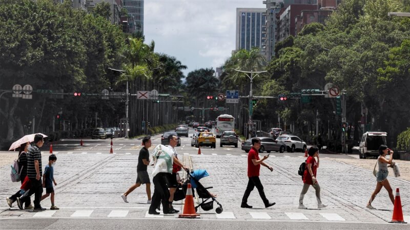 圖為台北市信義區民眾中午在豔陽下過馬路。中央社記者王飛華攝 113年7月7日