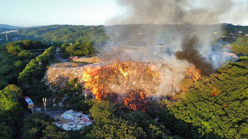 苗栗市西山垃圾掩埋場7日凌晨發生火警，濃煙直竄天際，消防局獲報派遣大批人力前往灌救，並申請空勤總隊直升機支援，全力搶救中。（民眾提供）中央社記者魯鋼駿傳真  113年7月7日