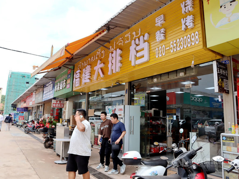 寮國旅遊業者觀察，中國旅客來到永珍，所有的消費幾乎都在中國城裡；台灣旅客較喜歡感受在地文化，吃飯與住宿多會選擇當地業者。圖為永珍中國城一家福建大排檔外的中國旅客。中央社記者陳家倫永珍攝  113年7月9日