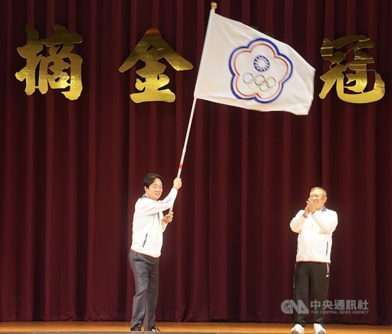 總統賴清德(左)9日南下高雄國家運動訓練中心,揮舞團旗,預祝旗開得勝。中央社記者董俊志攝 113年7月9日