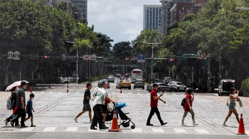 圖為台北市信義區街頭民眾在豔陽下過馬路。（中央社檔案照片）
