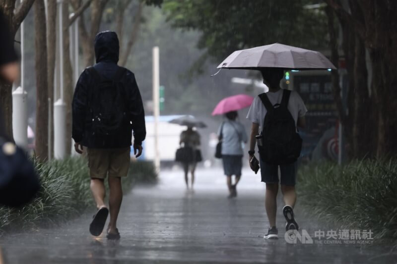 台北市松山區9日下午降下雨勢，街頭民眾撐傘、穿外套擋雨。中央社記者翁睿坤攝 113年7月9日