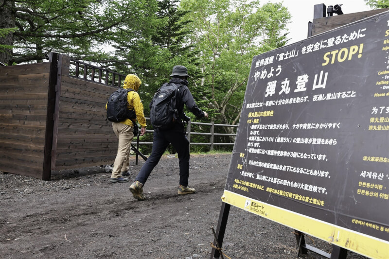 日本富士山靠山梨縣側的登山步道入口放置告示牌，提醒民眾留意通宵攻頂（彈丸登山）危險性。（共同社）