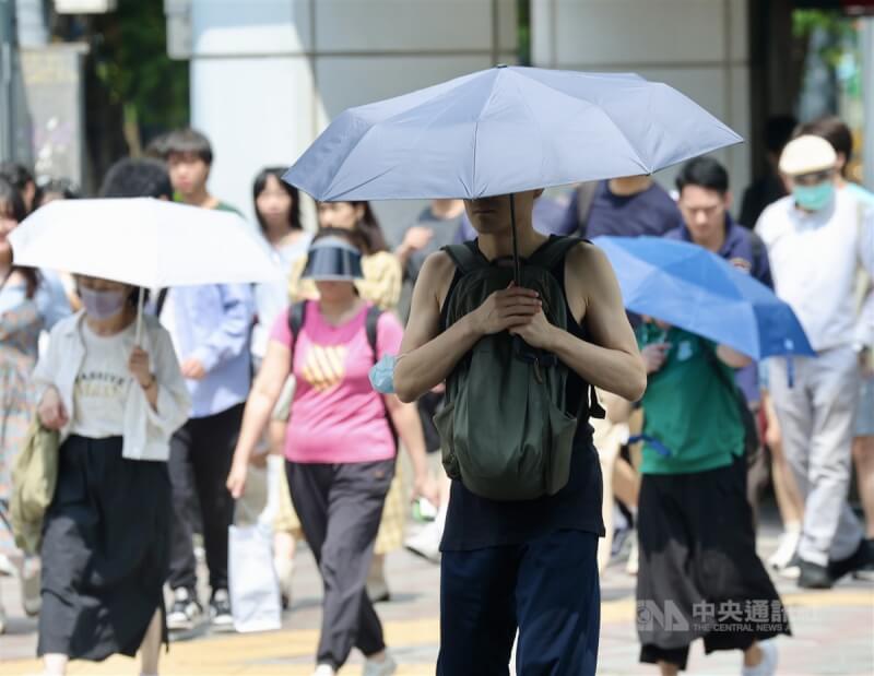 台北市中山區街頭民眾撐傘遮擋烈陽。（中央社檔案照片）