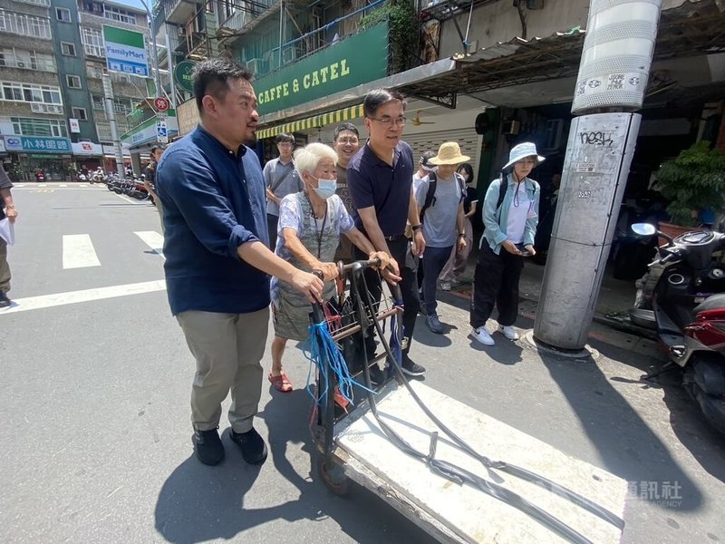 環境部長彭啓明（前左3）13日到南機場夜市親自體驗拾荒工作，與拾荒阿嬤一同在烈日下推著手推車，沿途拜訪各商家及攤販收集鐵罐、紙箱等回收物。中央社記者吳欣紜攝  113年7月13日