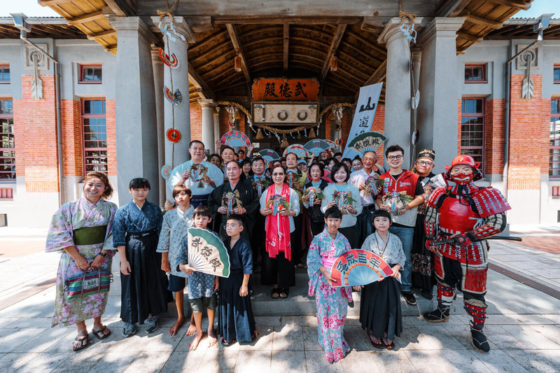 高雄市文化局13日舉辦市定古蹟「武德殿」落成百年紀念活動，與會眾人手持象徵避邪祈福的「注連繩」，齊聲高喊「武德殿100歲生日快樂」，為這座風華古蹟歡慶百歲生日。（高雄市文化局提供）中央社記者林巧璉傳真  113年7月13日