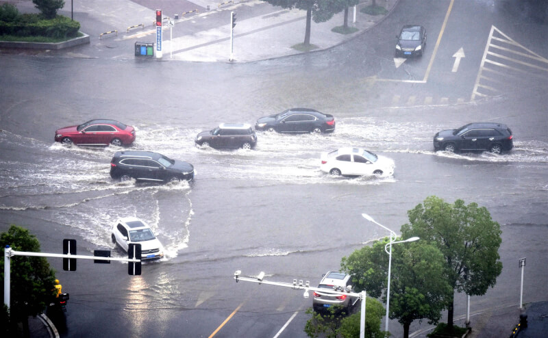 中國安徽省銅陵街道13日因強降雨積水，車輛如陸上行舟。（中新社）