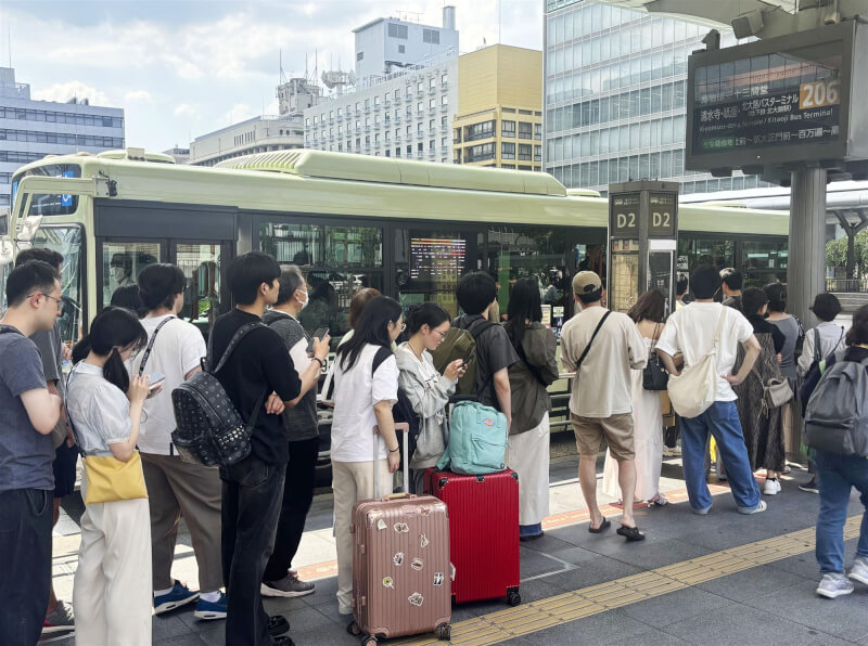 京都市政府呼籲觀光客不要攜帶大型行李箱搭公車，但這種情況仍然屢見不鮮。圖為在京都車站前等待巴士的人群。（共同社）