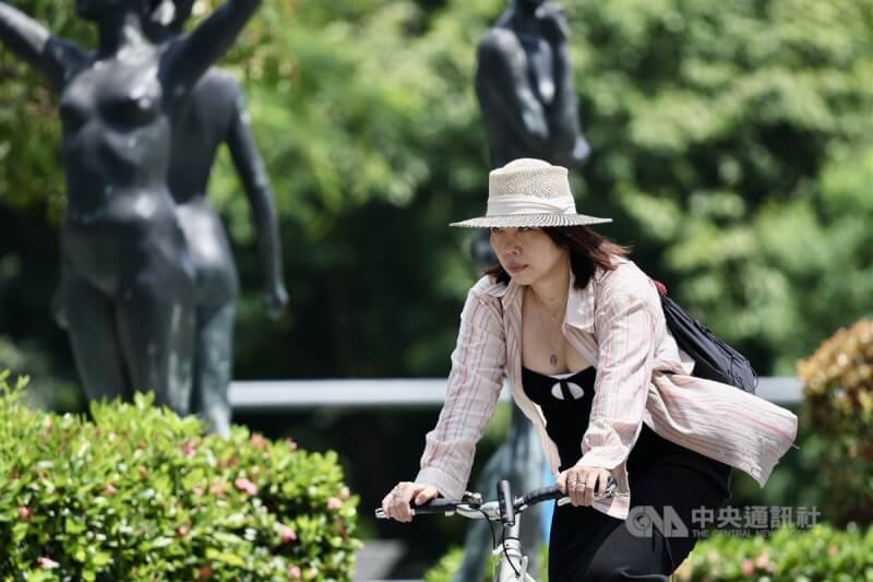 台北市中正區，民眾騎單車戴帽子遮陽。中央社記者王飛華攝 113年7月14日