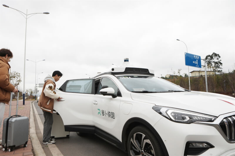 去年民眾在重慶搭乘無人駕駛計程車「蘿蔔快跑」。（中新社）