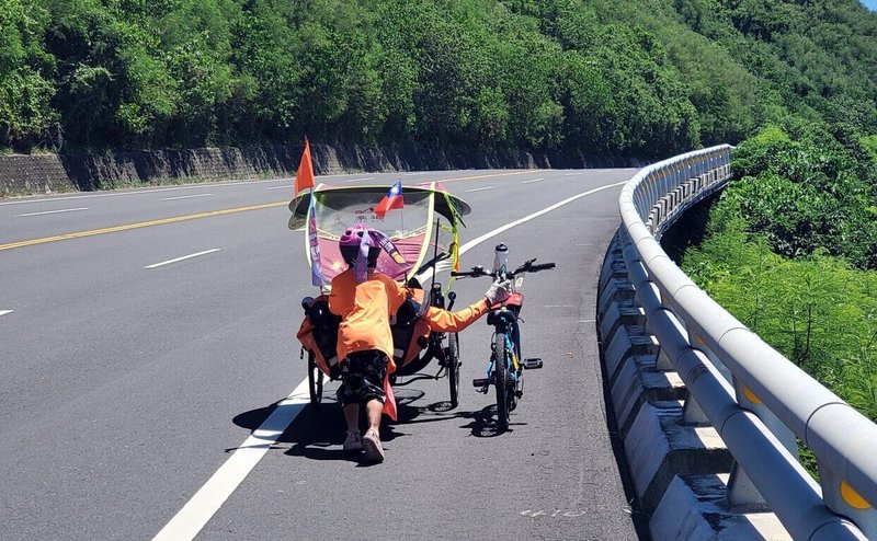 雲林縣長愛家園育幼院今年暑期由志工帶領院童騎自行車環島，80歲志工陪6歲院童騎車，後方志工捕捉到2人互推上斜坡溫馨畫面。（吳文輝提供）中央社記者黃國芳傳真  113年7月19日