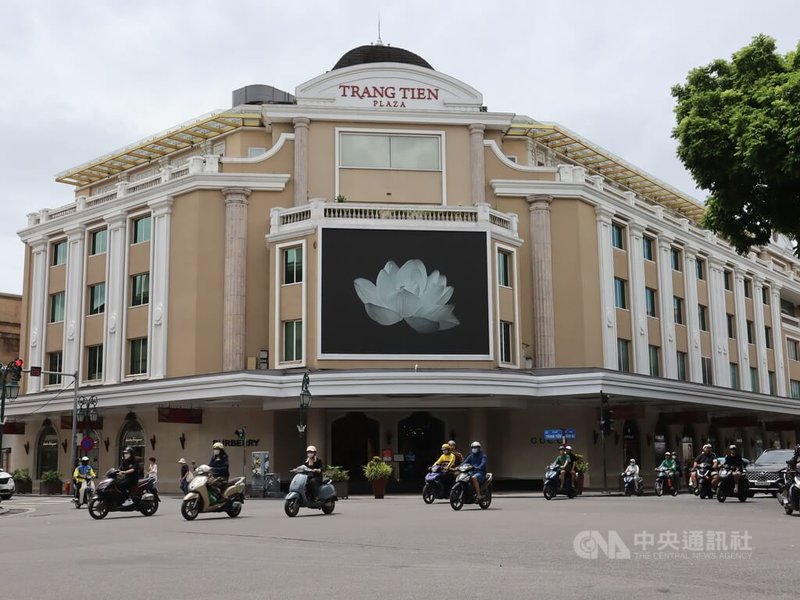 越共總書記阮富仲19日病逝，河內市景點還劍湖畔一家商場的電子看板20日以一張黑底襯著白蓮花的圖片致哀。中央社記者陳家倫河內攝 113年7月20日