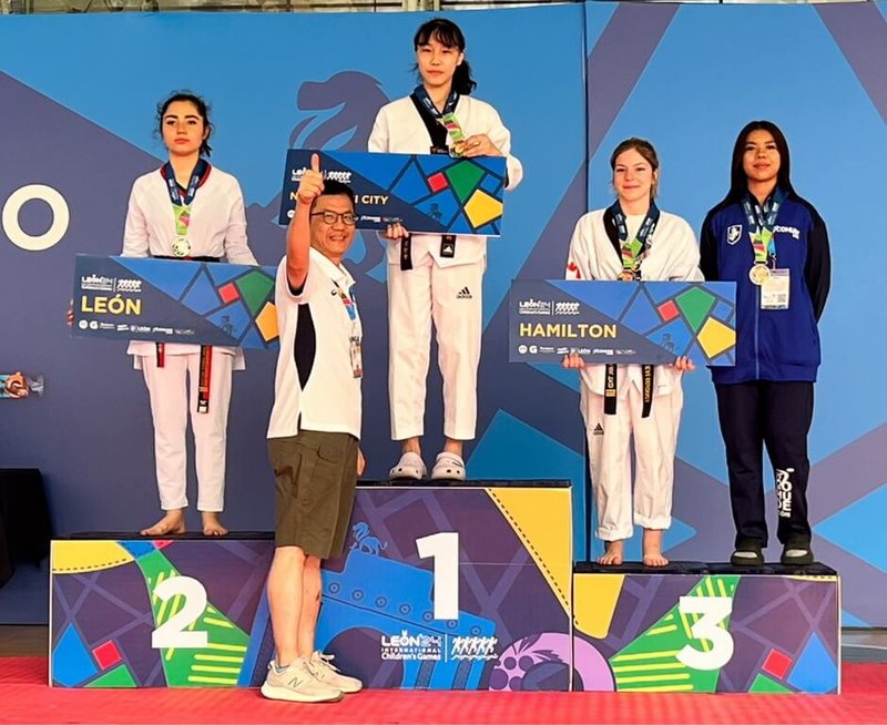新北市小將在2024國際少年運動會表現亮眼,新北城市代表、市府副秘書長張其強(前中)應主辦單位邀請,頒發跆拳道女子59公斤級金牌給獲獎選手林立羽(後左2)。(新北市體育局提供)中央社記者黃旭昇新北市傳真 113年7月20日