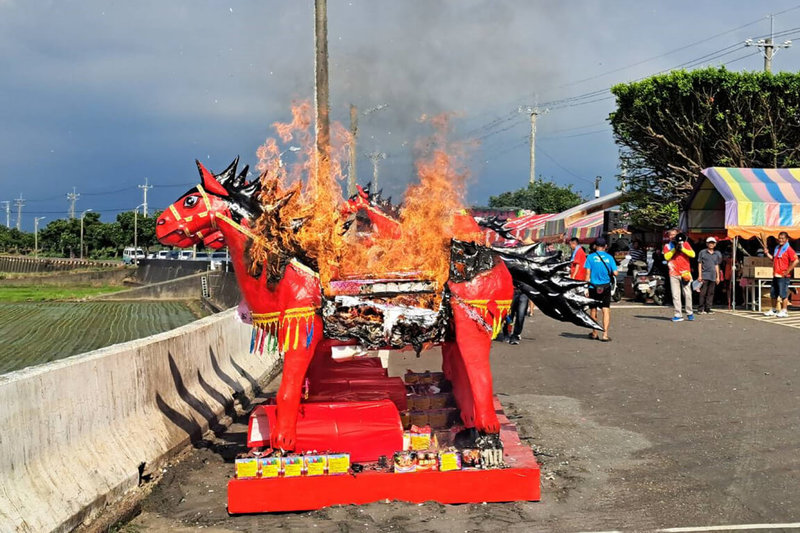 台南「後壁崁頂放火馬宗教文化祭」22日下午在菁豐里崁頂部落舊八掌溪畔登場，蜂炮四射後，以竹架和紙紮做成的火馬陸續燃燒。（後壁區公所提供）中央社記者楊思瑞台南傳真  113年7月22日