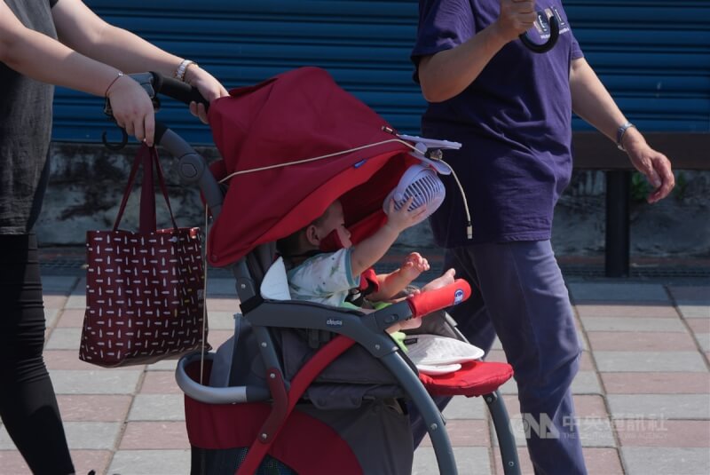 圖為民眾在新北市八里老街逛街，幼兒推車裝有小型風扇消暑。（中央社檔案照片）