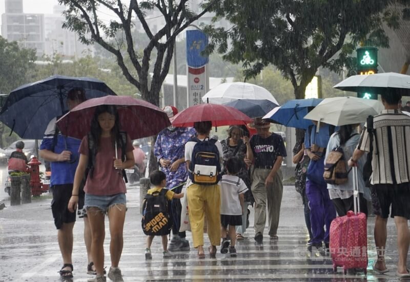 圖為高雄市新興區23日傍晚出現雨勢，民眾紛紛撐起雨傘。中央社記者董俊志攝 113年7月23日