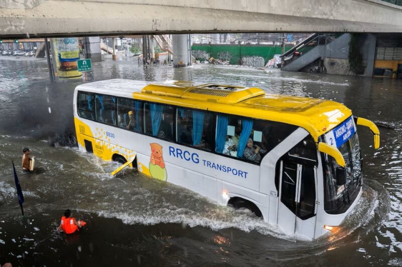 颱風凱米影響，24日馬尼拉大雨，一輛巴士穿過被淹水的道路。（路透社）